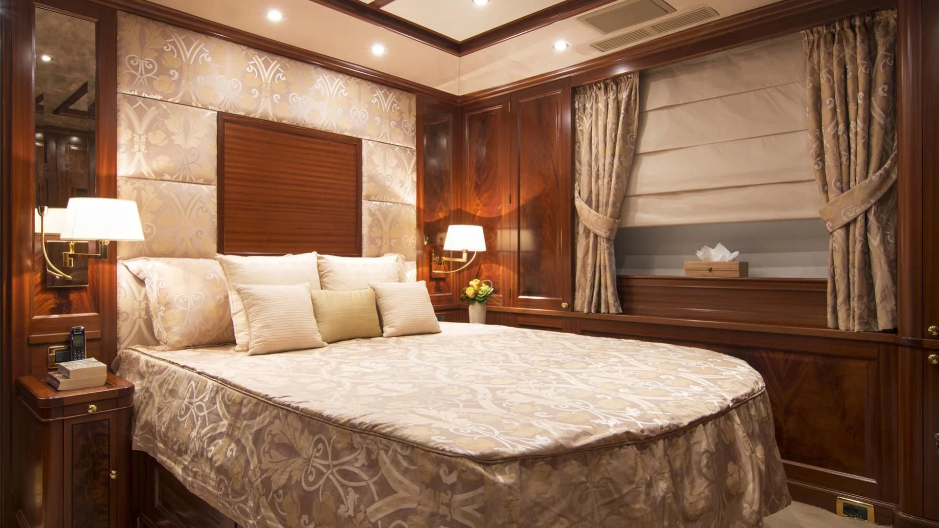 a large bed with a white comforter and pillows aboard OPTION B Yacht for Charter