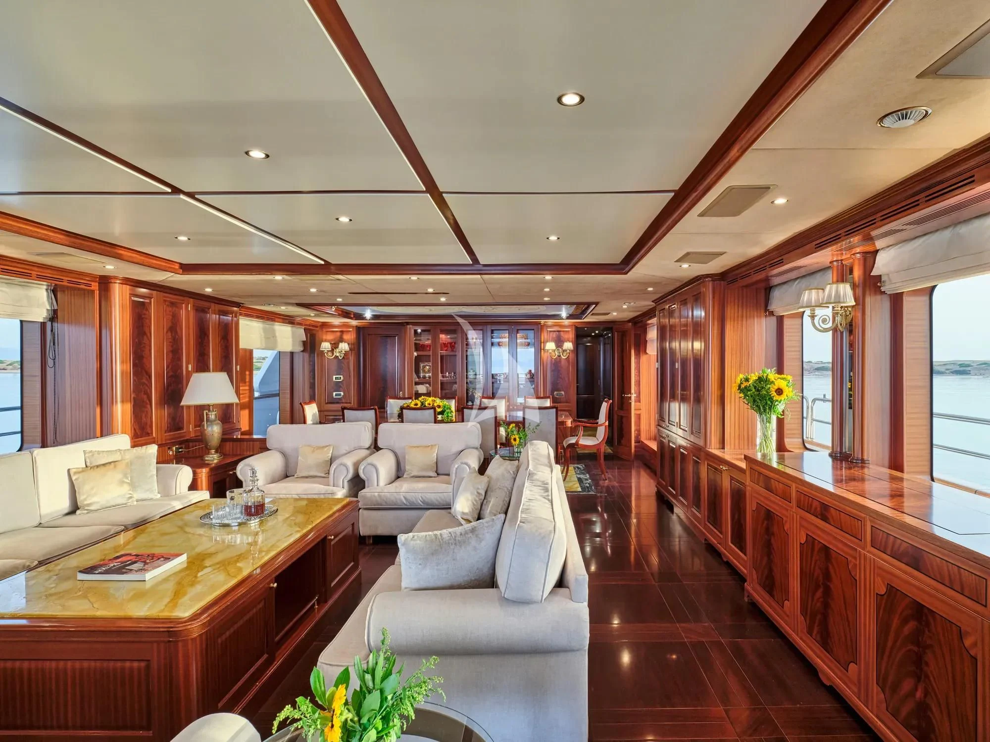 a living room with a large wood table and couches aboard OPTION B Yacht for Charter