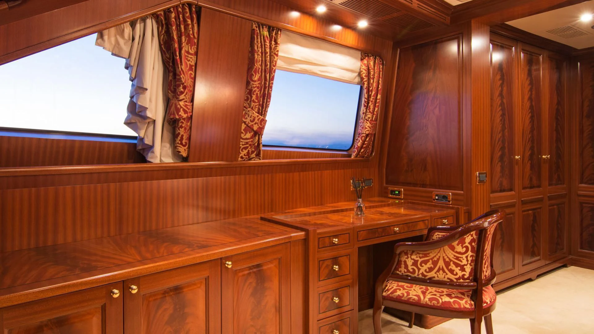 a room with wooden cabinets and a chair aboard OPTION B Yacht for Charter