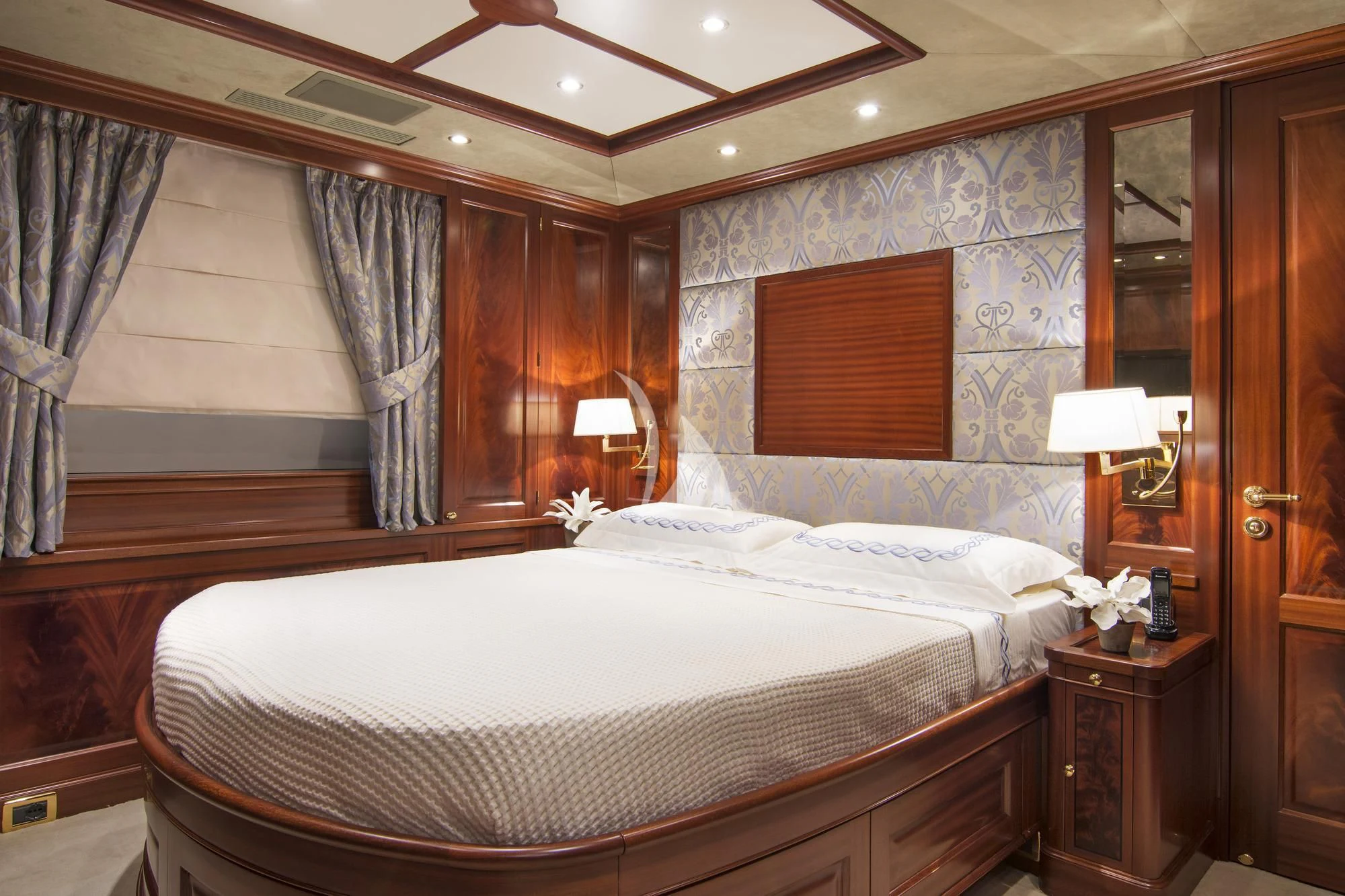 a room with a bed and a mirror aboard OPTION B Yacht for Charter