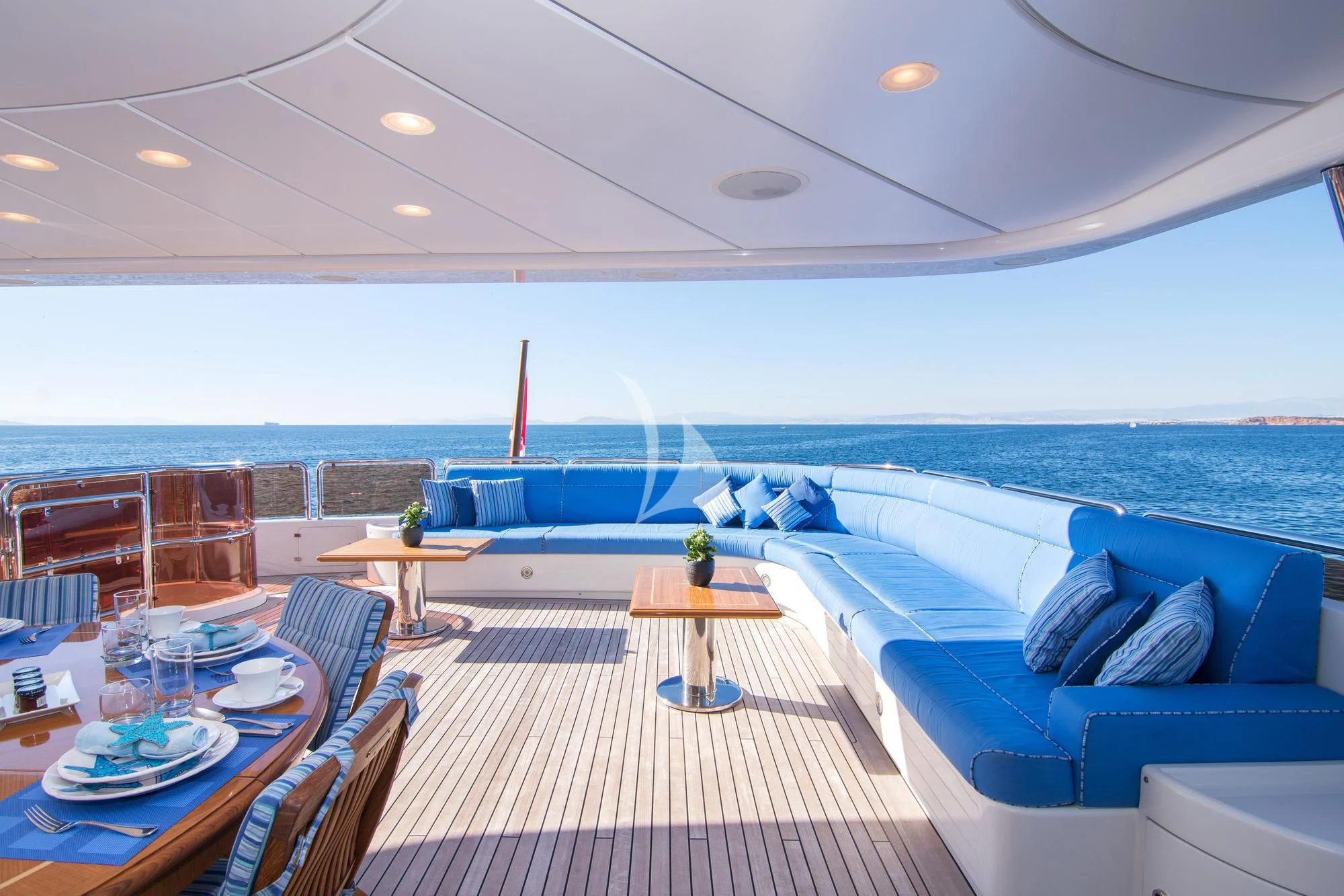 a room with a table and chairs and a large body of water aboard OPTION B Yacht for Charter