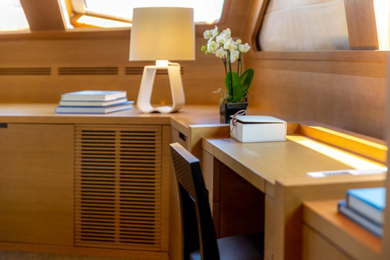 a desk with a lamp and a book on it aboard MINA Yacht for Sale