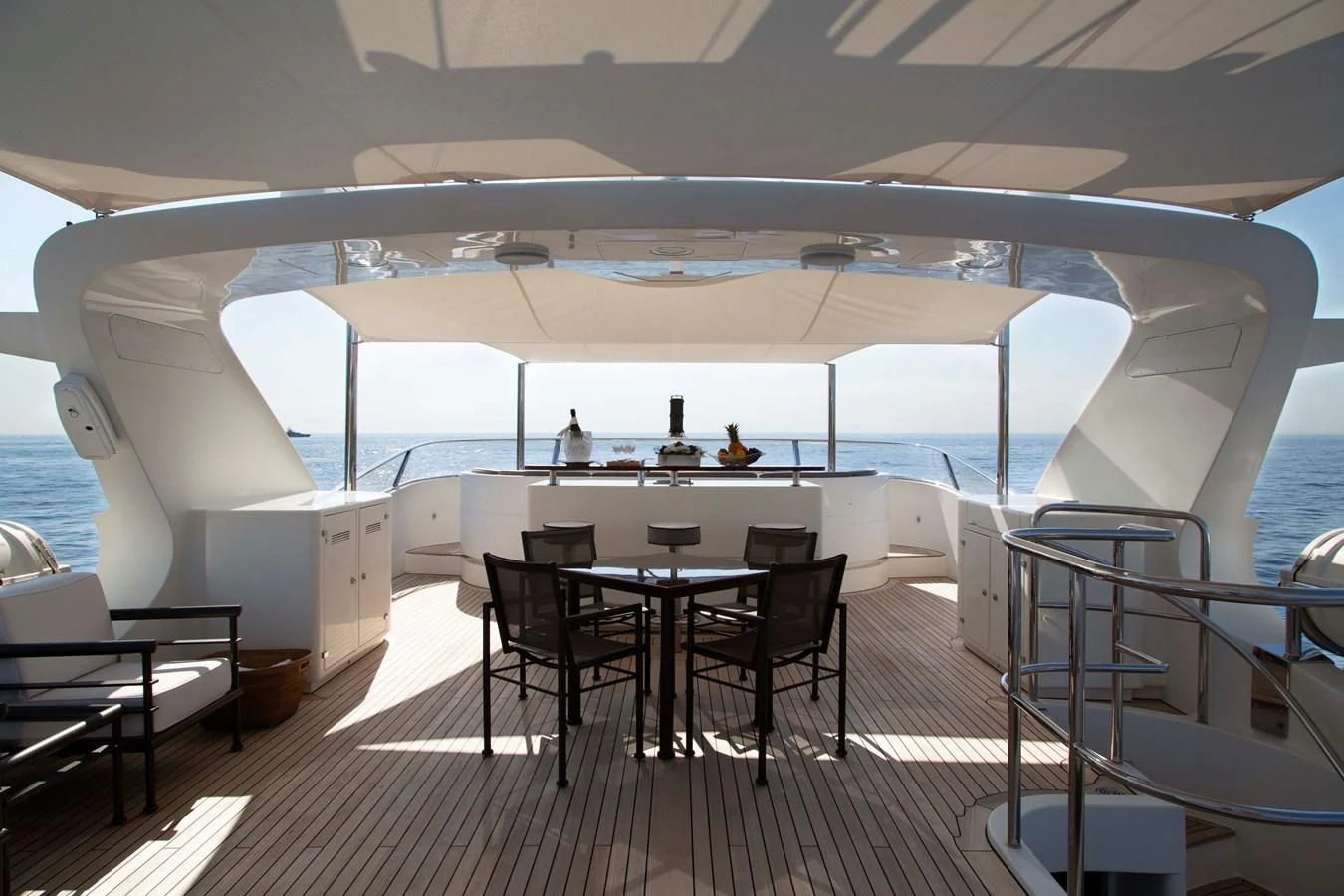 a large white boat with a table and chairs on a deck aboard MINA Yacht for Sale