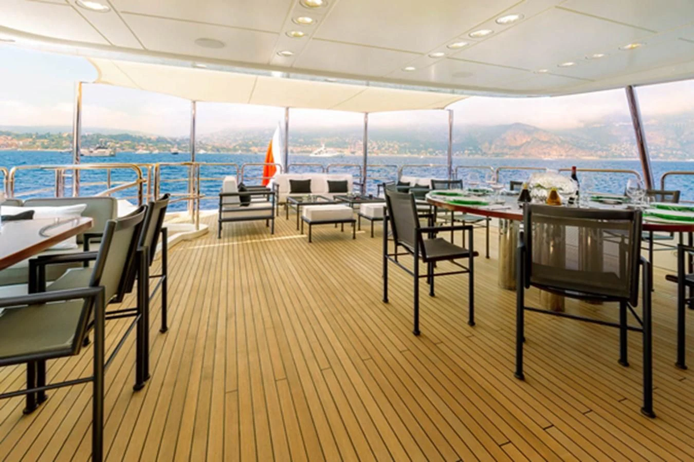 a deck with tables and chairs aboard MINA Yacht for Sale