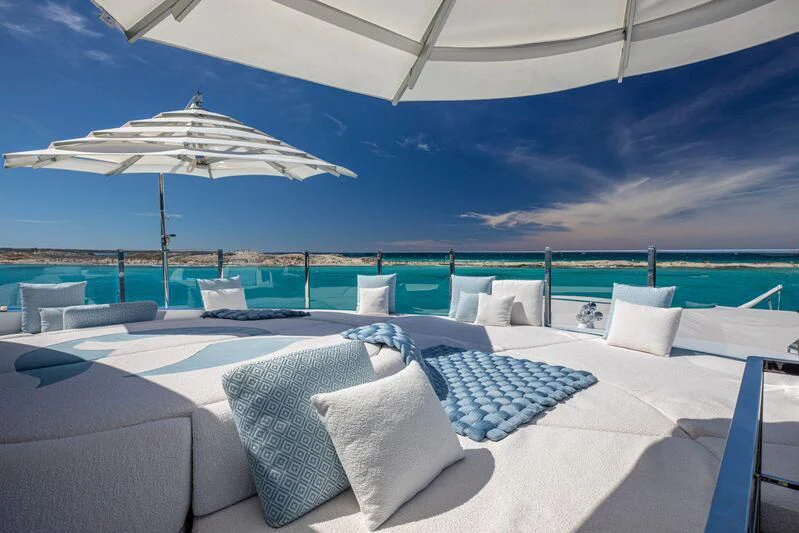 a large lounge area with a large umbrella over it aboard OCEANBIRD Yacht for Sale