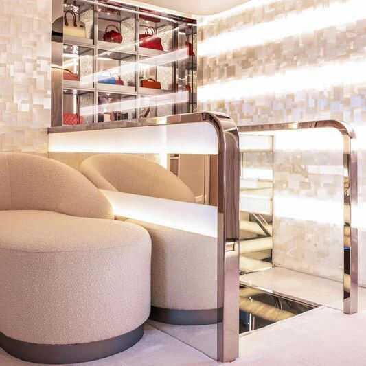 a room with a couple of couches and a shelf with books aboard OCEANBIRD Yacht for Sale