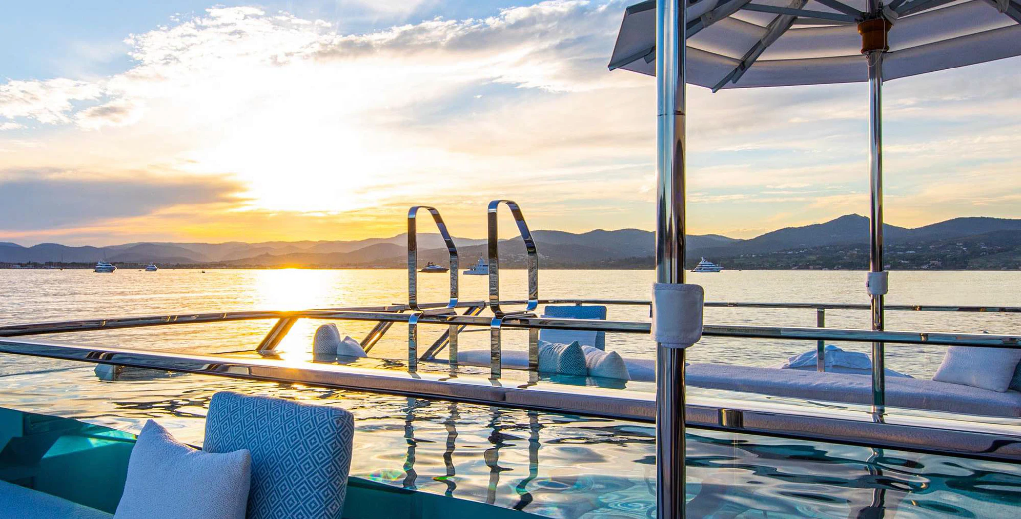 a deck with a view of the water and mountains in the background aboard OCEANBIRD Yacht for Sale