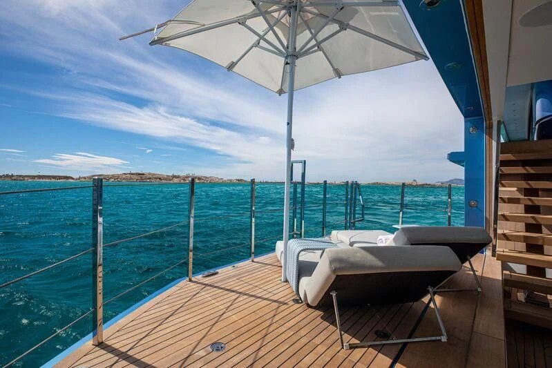 a deck with a chair and an umbrella on it aboard OCEANBIRD Yacht for Sale