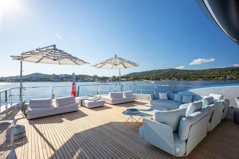 a lounge area with lounge chairs and umbrellas on a deck aboard OCEANBIRD Yacht for Sale
