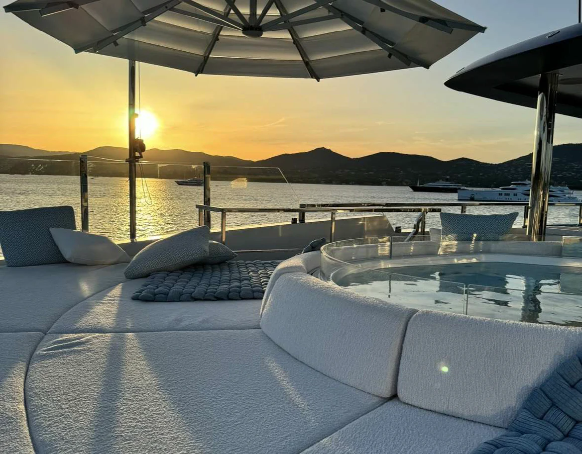 a lounge chair on a deck overlooking a body of water aboard OCEANBIRD Yacht for Sale
