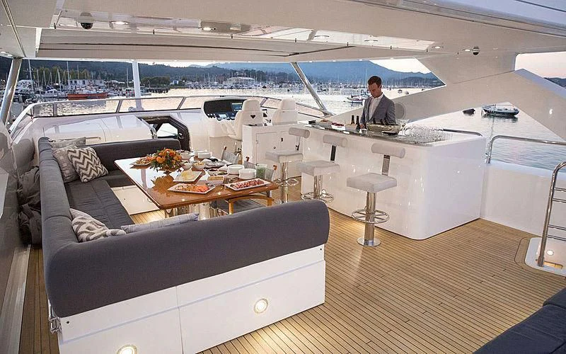 a person sitting at a table in a room with a large window aboard EMRYS Yacht for Sale