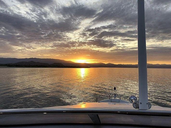 a sunset over a body of water aboard EMRYS Yacht for Sale