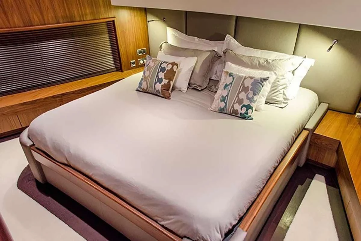 a bed with white sheets and pillows aboard EMRYS Yacht for Sale