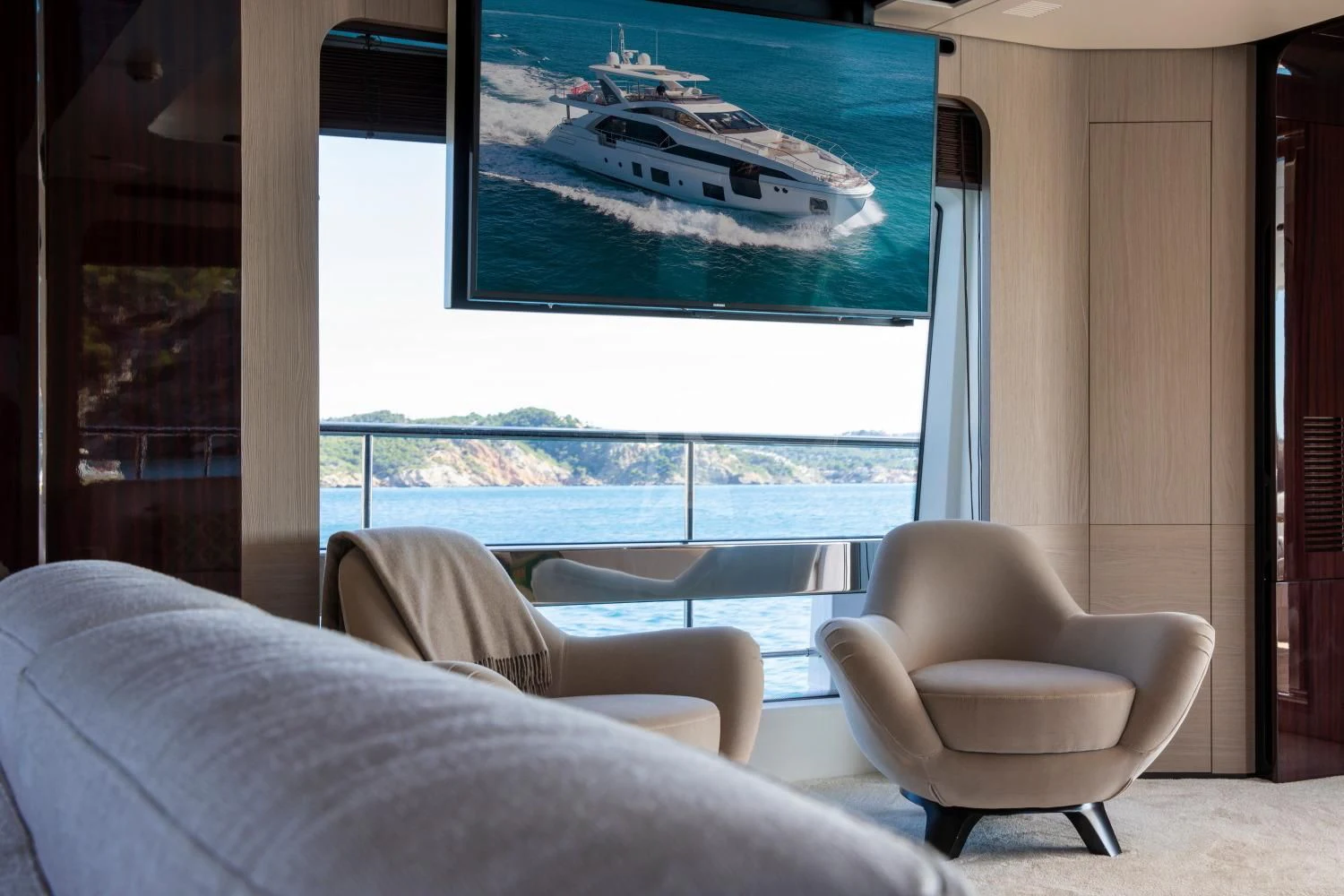 a room with a couch and a large window with a view of the water aboard CLOUDY BAY Yacht for Sale