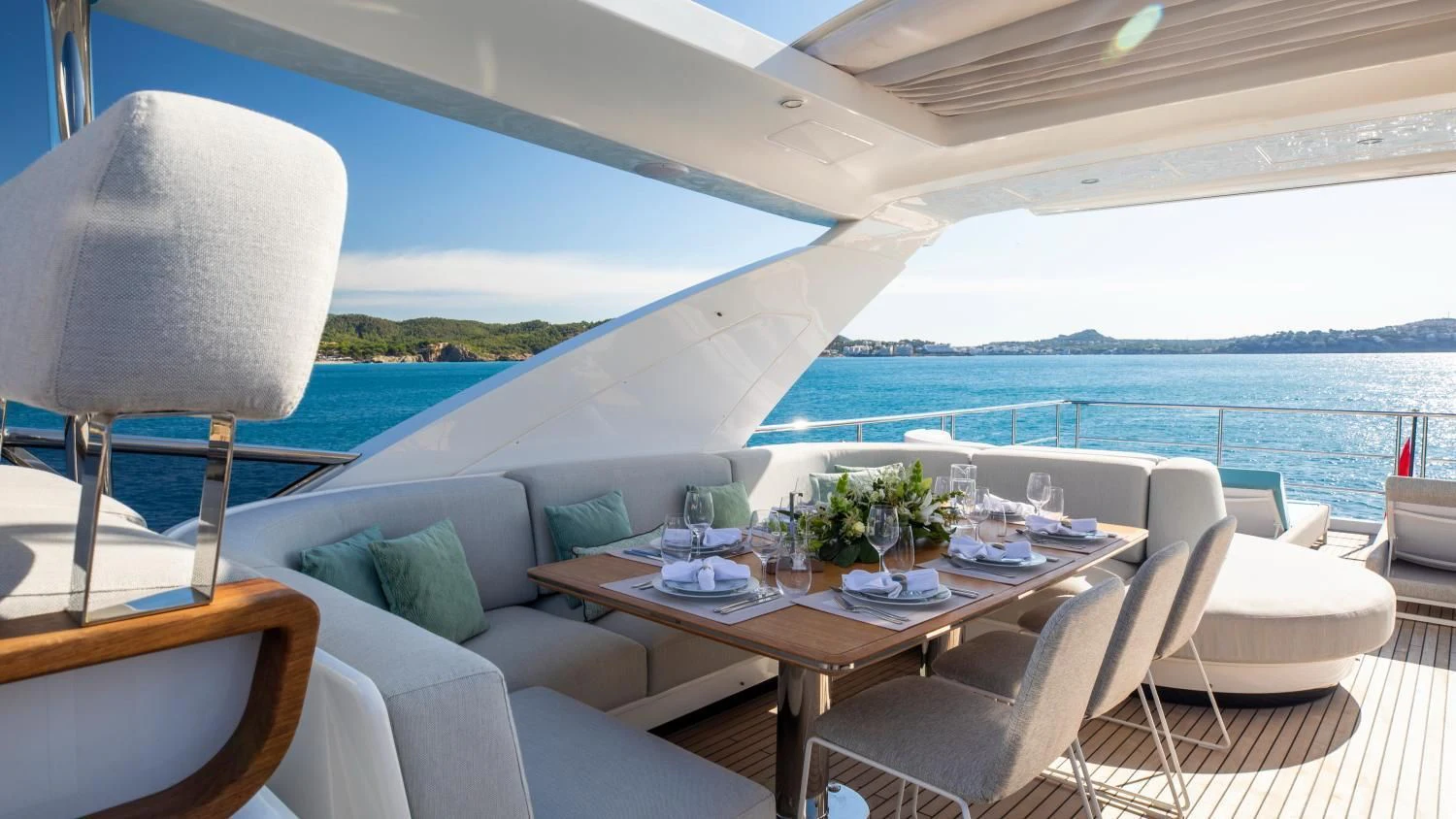 a table with chairs and a view of the ocean aboard CLOUDY BAY Yacht for Sale
