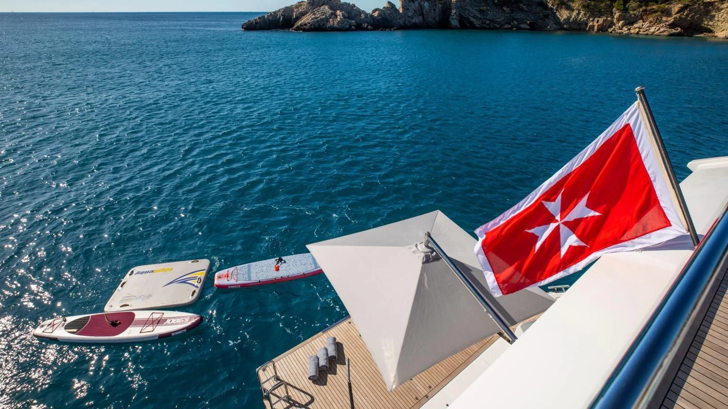 a boat with a flag on it aboard CLOUDY BAY Yacht for Sale