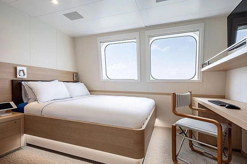 a room with a bed and desk aboard HODOR Yacht for Charter