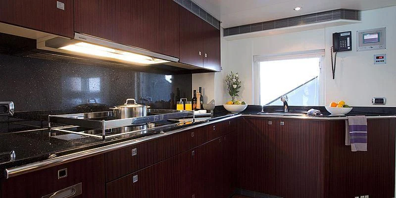 a kitchen with wooden cabinets aboard AILISH V Yacht for Sale
