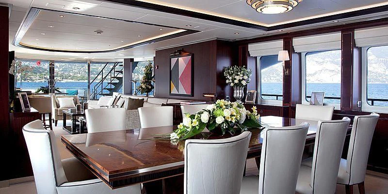 a room with tables and chairs aboard AILISH V Yacht for Sale