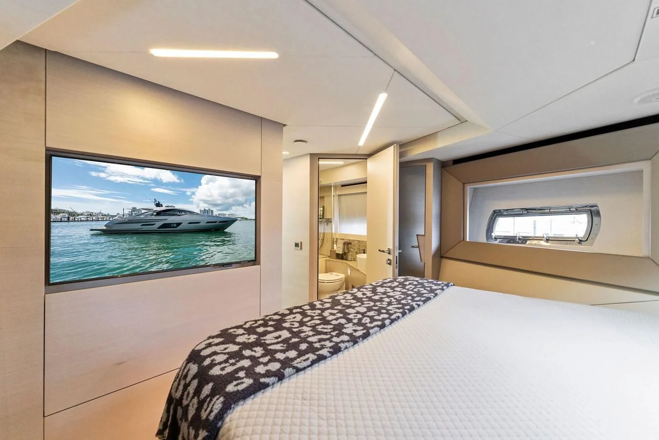 a large flat screen television in a room with a bed and a large window aboard PERSHING 7X Yacht for Sale