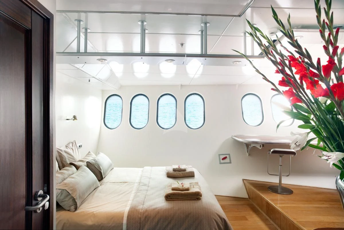 a room with a bed and a table aboard DWINGER Yacht for Sale