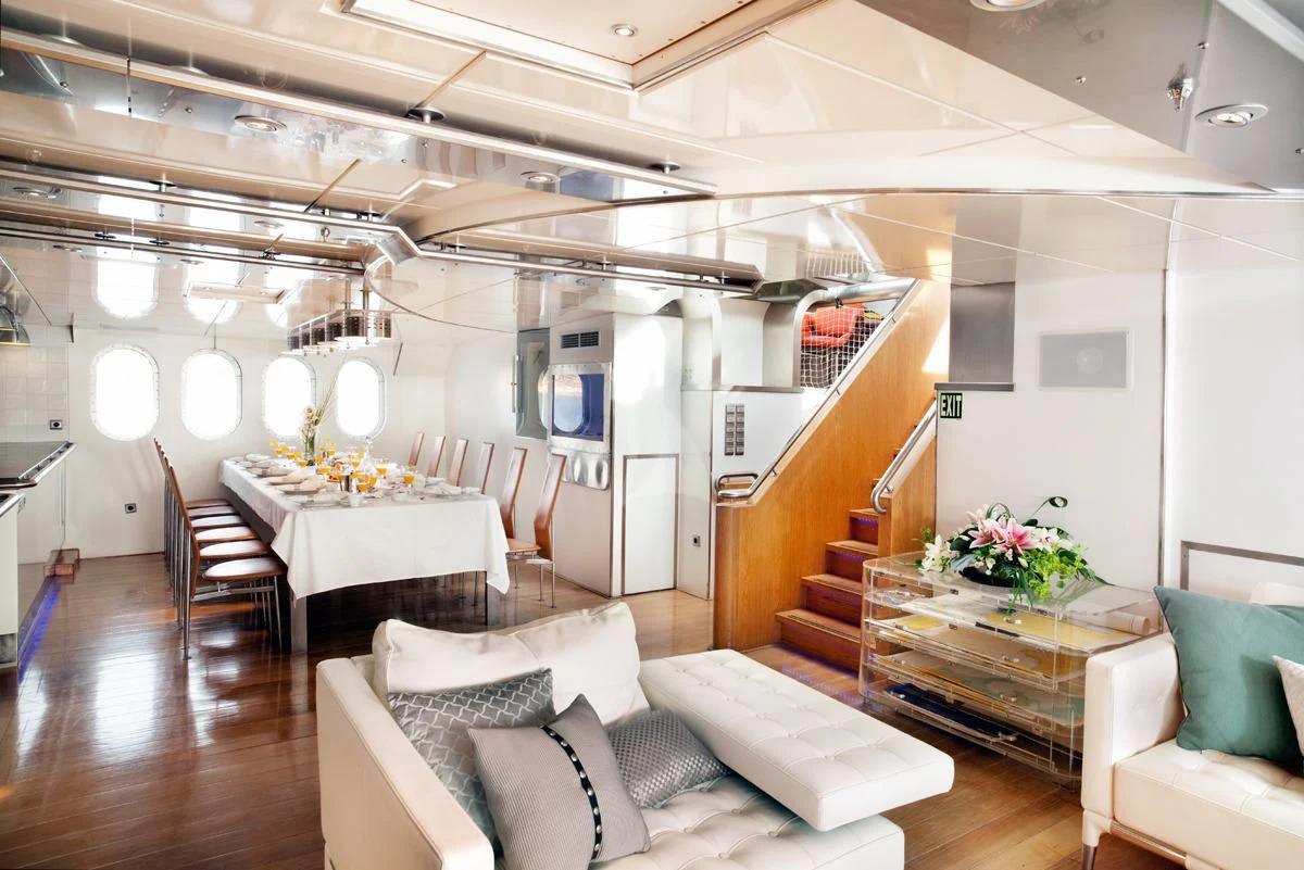 a room with a staircase and couches aboard DWINGER Yacht for Sale