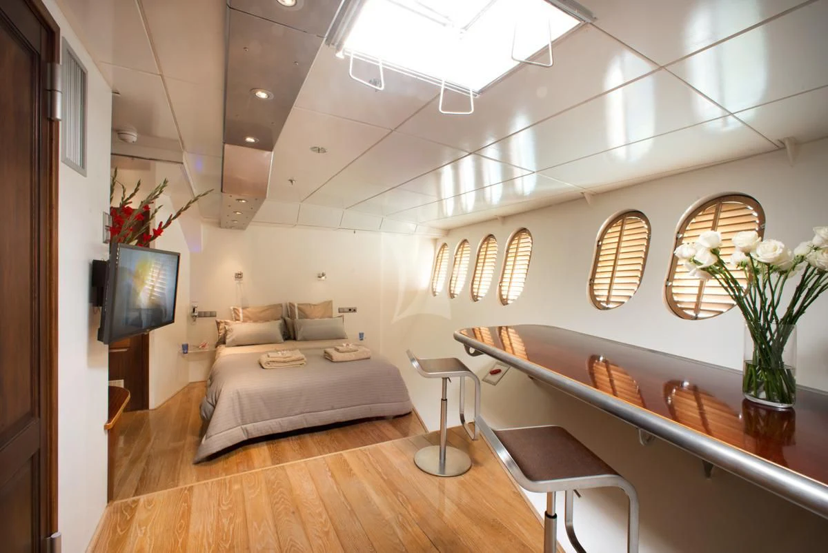 a living room with a bed and a table aboard DWINGER Yacht for Sale