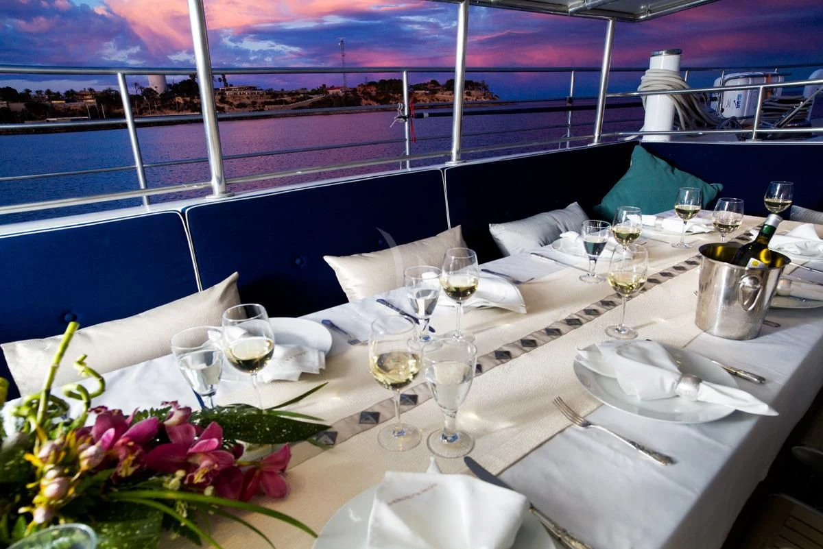 a table with white plates and glasses aboard DWINGER Yacht for Sale