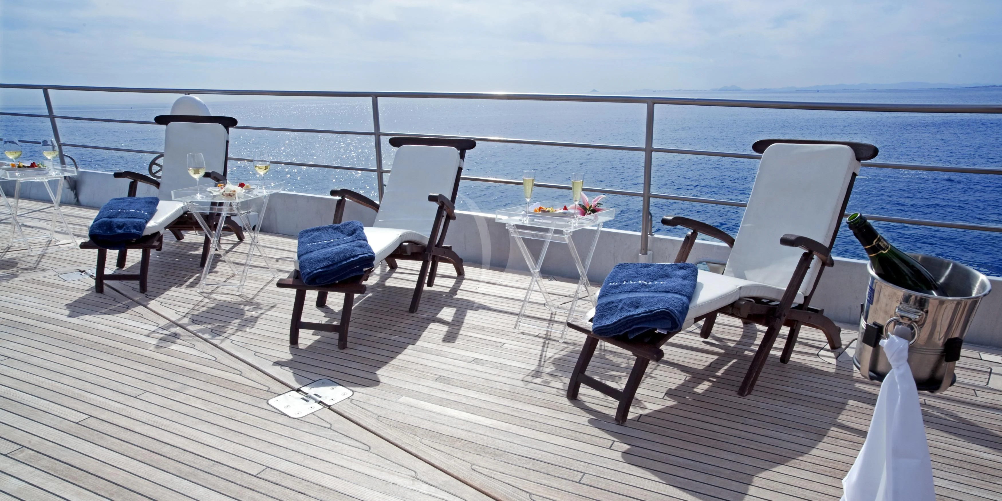 a deck with chairs and tables on it aboard DWINGER Yacht for Sale
