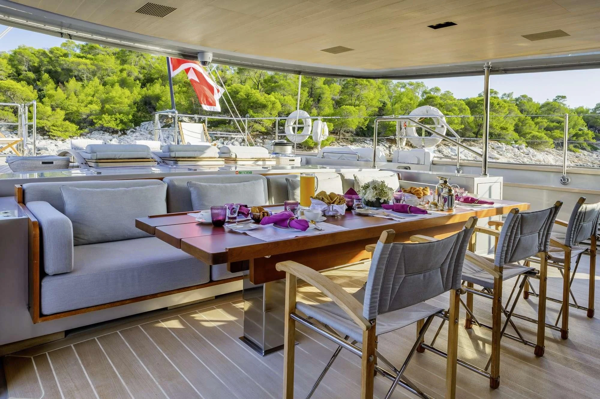 a table with chairs and a couch on a deck aboard BARACUDA VALLETTA Yacht for Sale