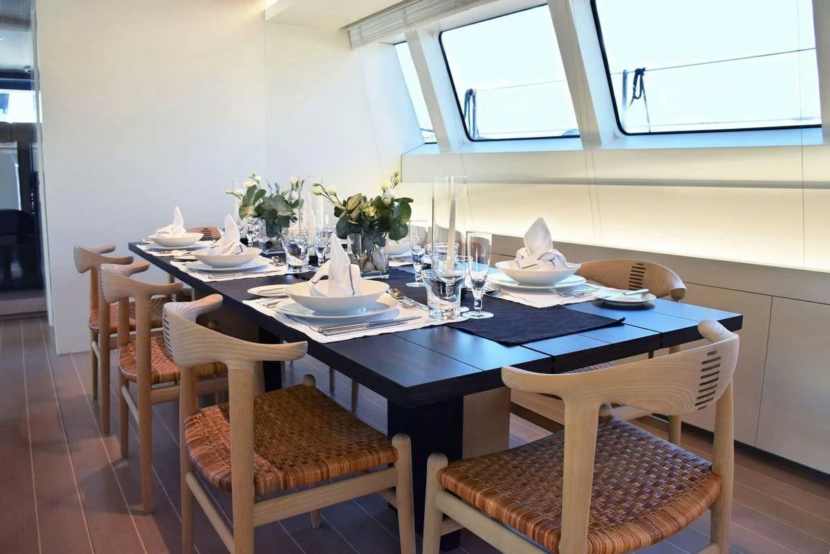 a table set with plates and chairs aboard BARACUDA VALLETTA Yacht for Sale