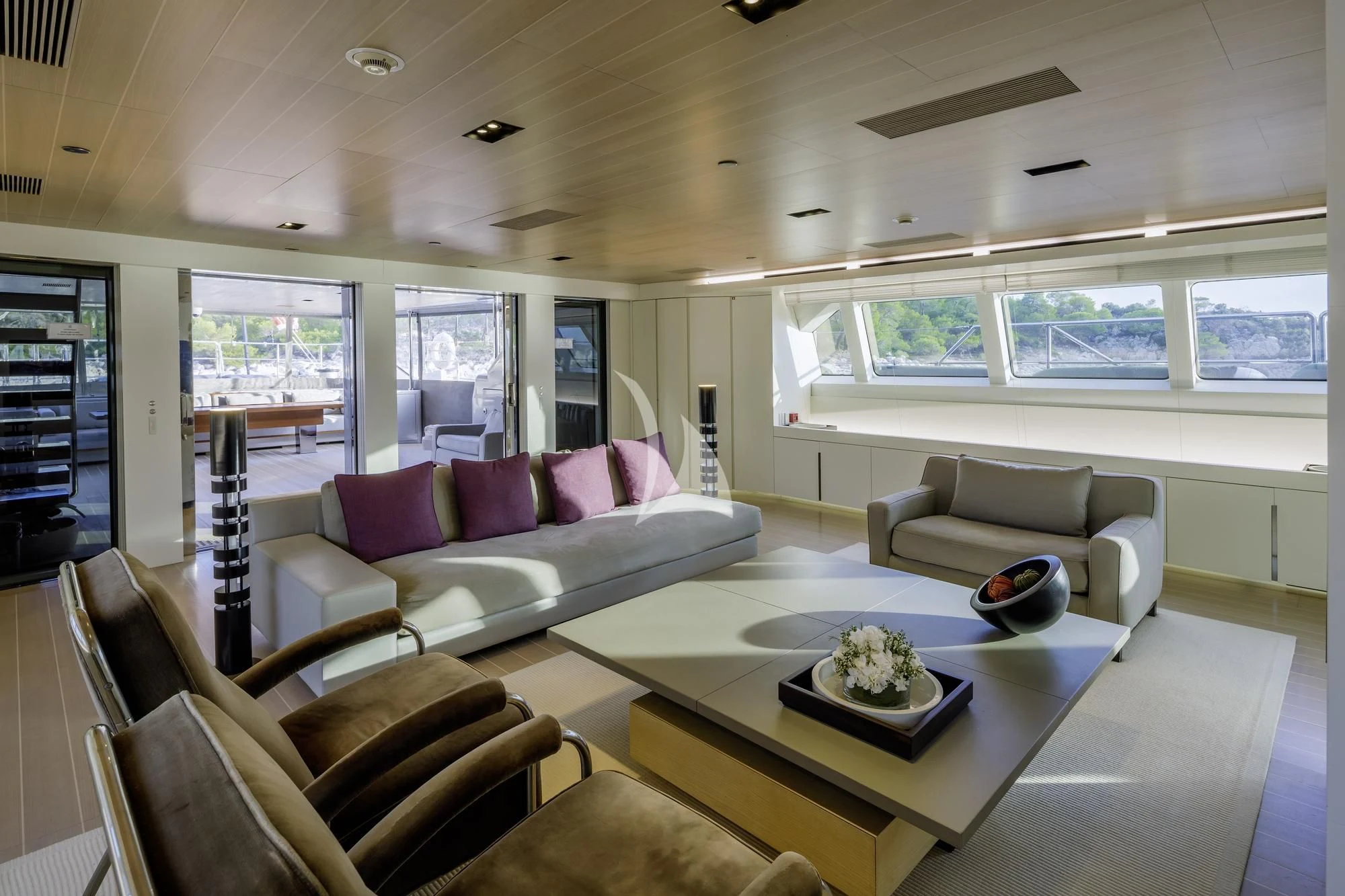 a living room with a table and couches aboard BARACUDA VALLETTA Yacht for Sale