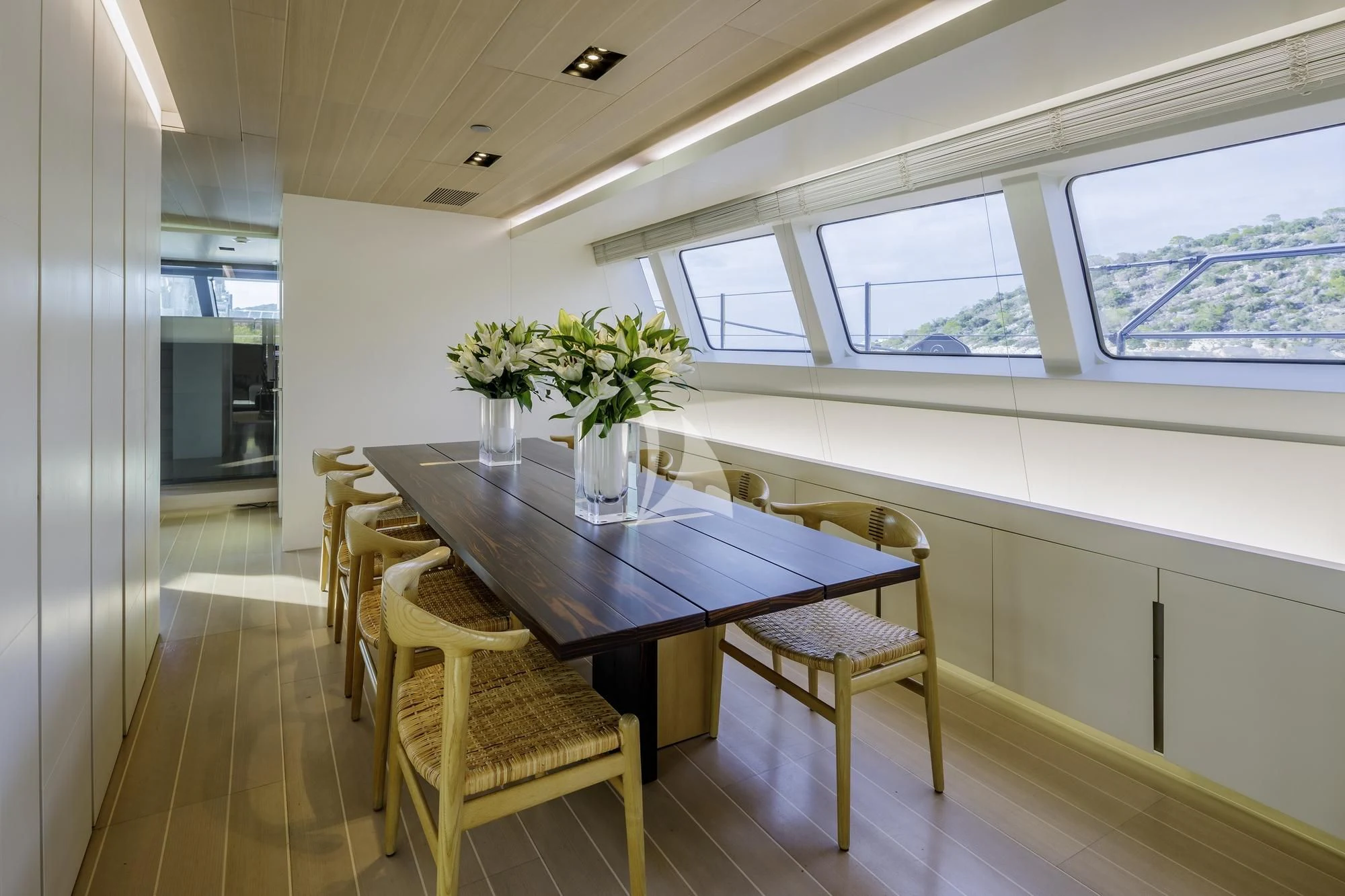 a dining table and chairs in a room with a window aboard BARACUDA VALLETTA Yacht for Sale