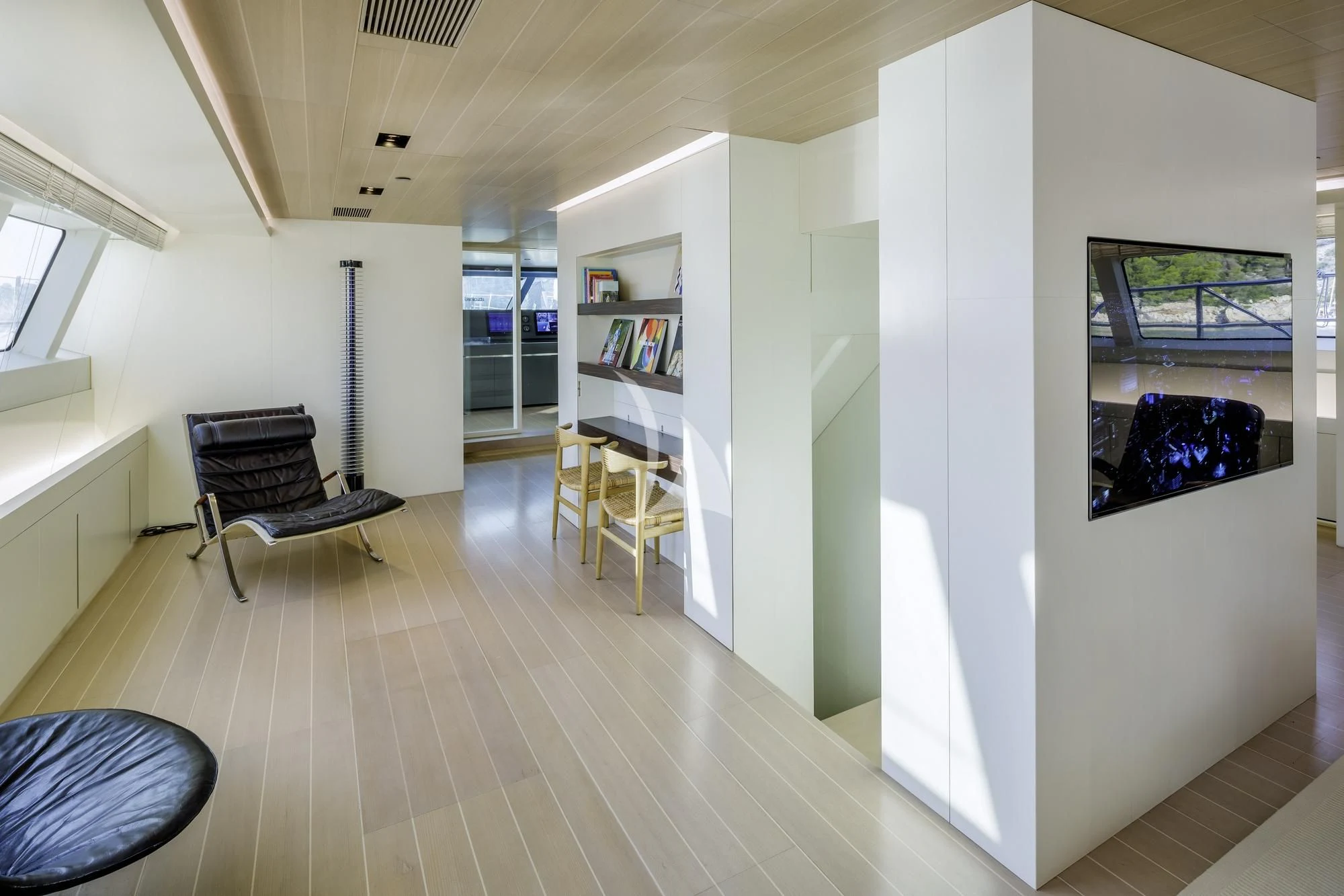 a room with a table chairs and a shelf with books aboard BARACUDA VALLETTA Yacht for Sale