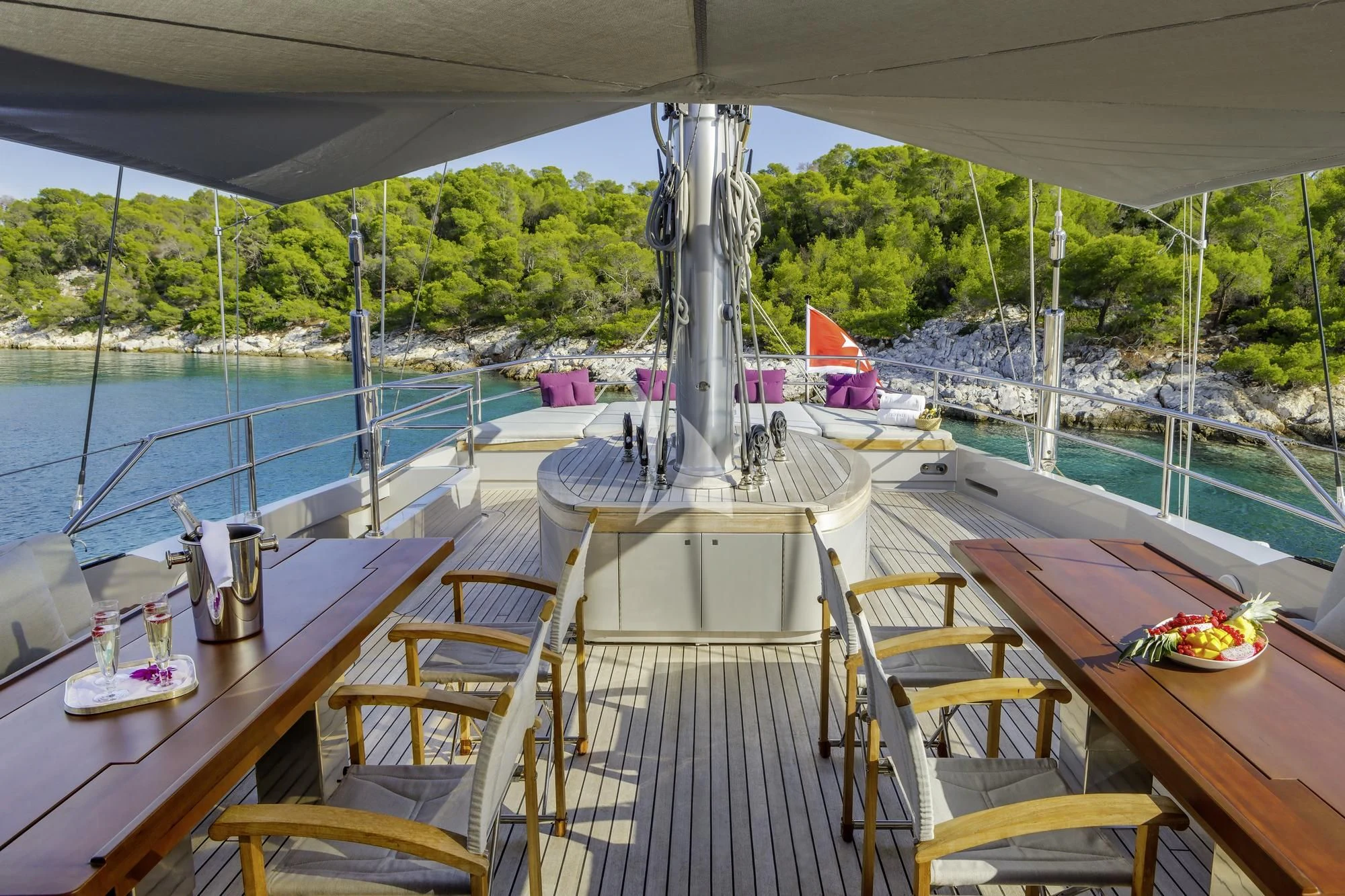 a deck with a table and chairs and a large water fountain aboard BARACUDA VALLETTA Yacht for Sale