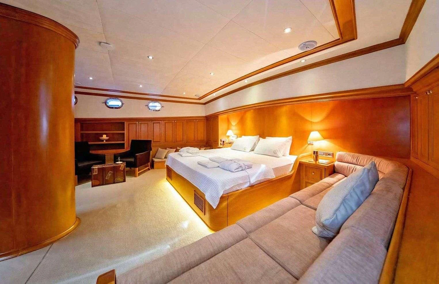 a hotel room with a bed and a chair aboard BABYLON Yacht for Sale