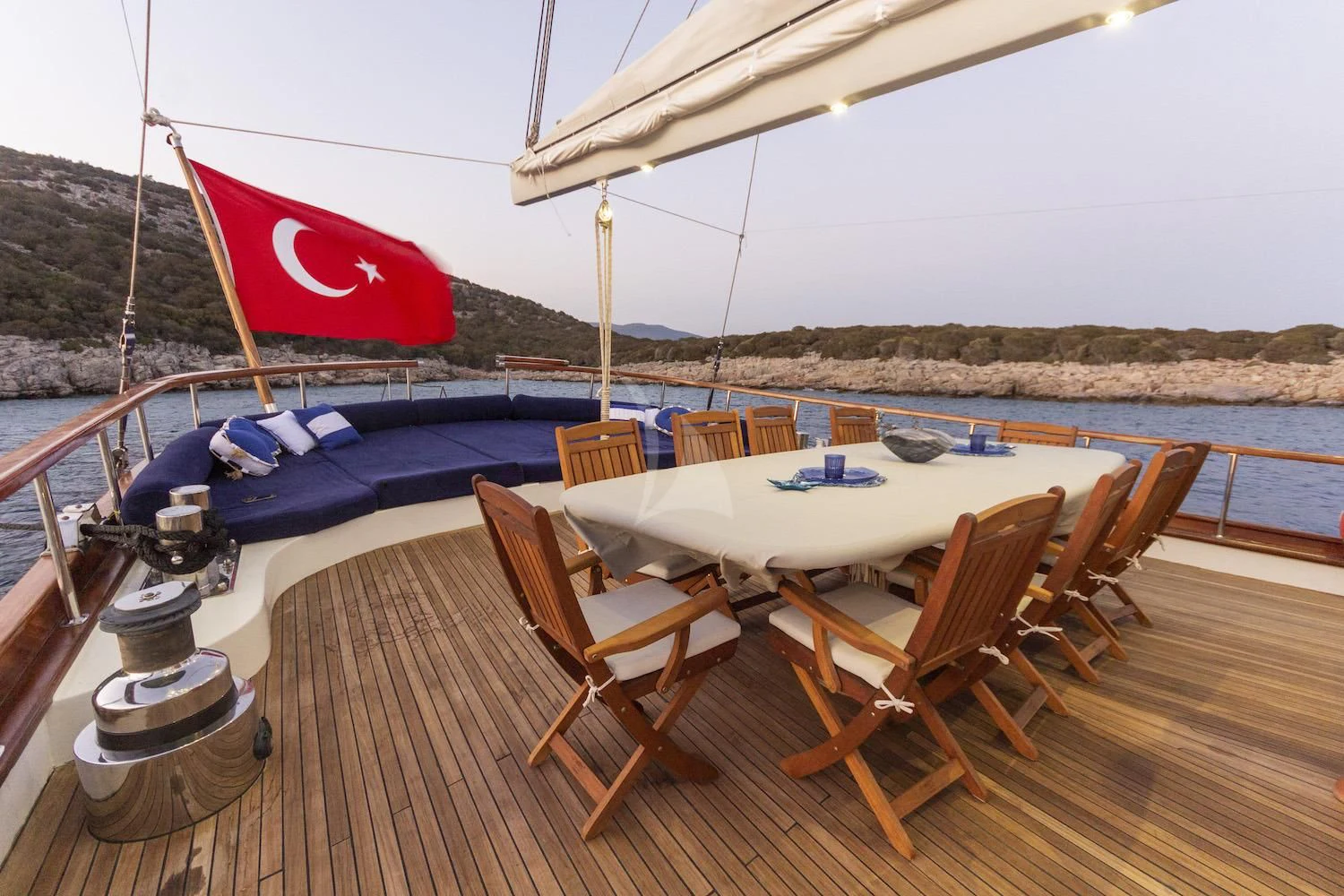 a deck with chairs and a table on it aboard BABYLON Yacht for Sale