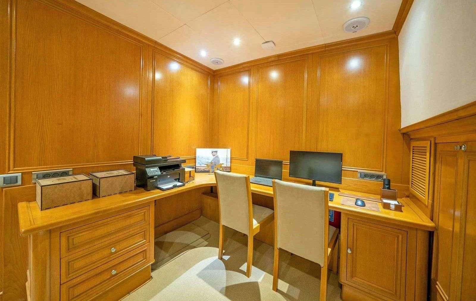 a room with a desk and chairs aboard BABYLON Yacht for Sale