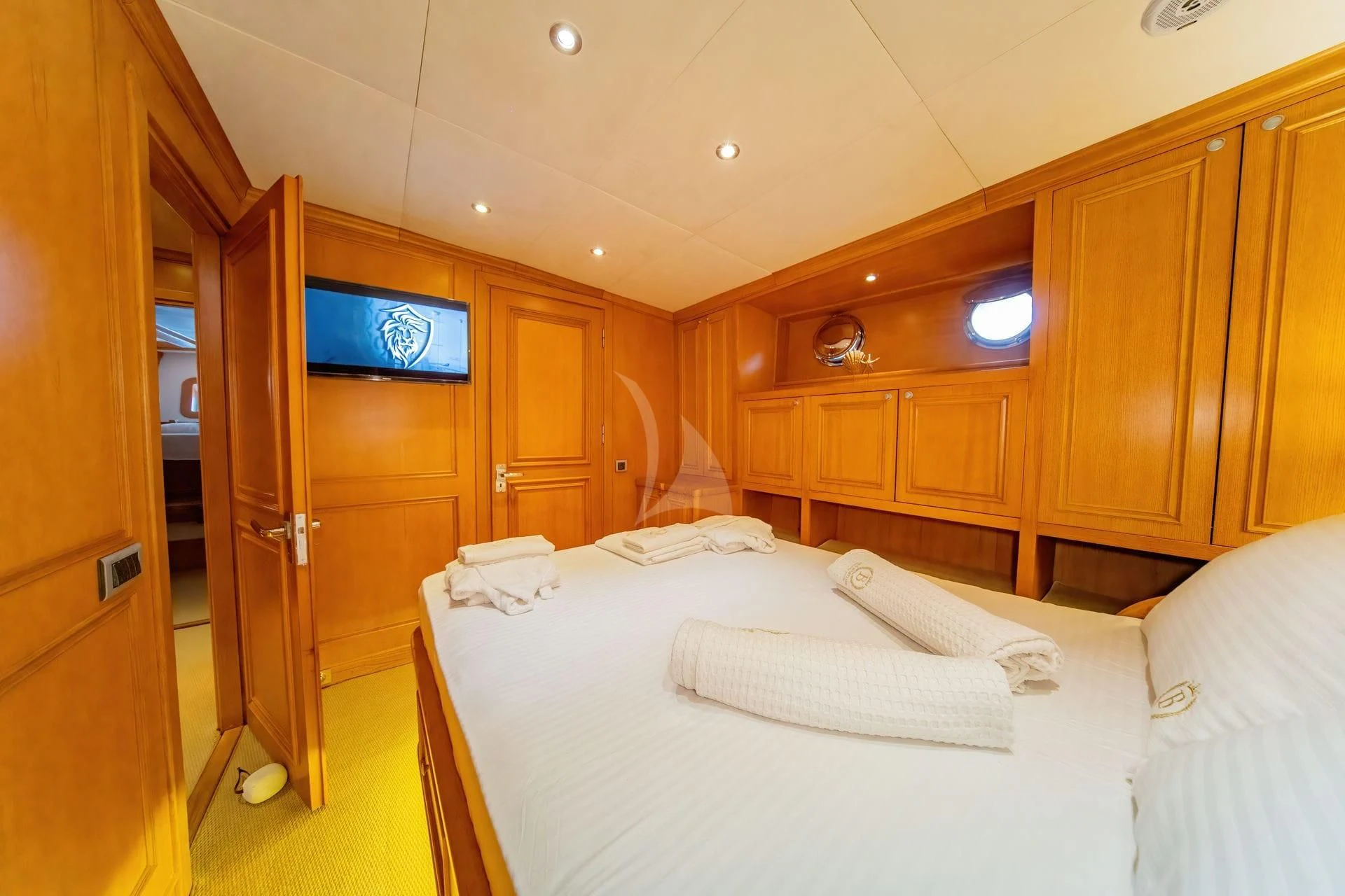 a room with wooden cabinets and a bed aboard BABYLON Yacht for Sale
