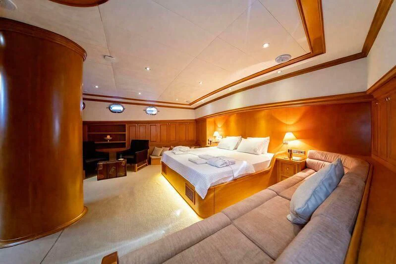 a room with a bed and a chair aboard BABYLON Yacht for Sale