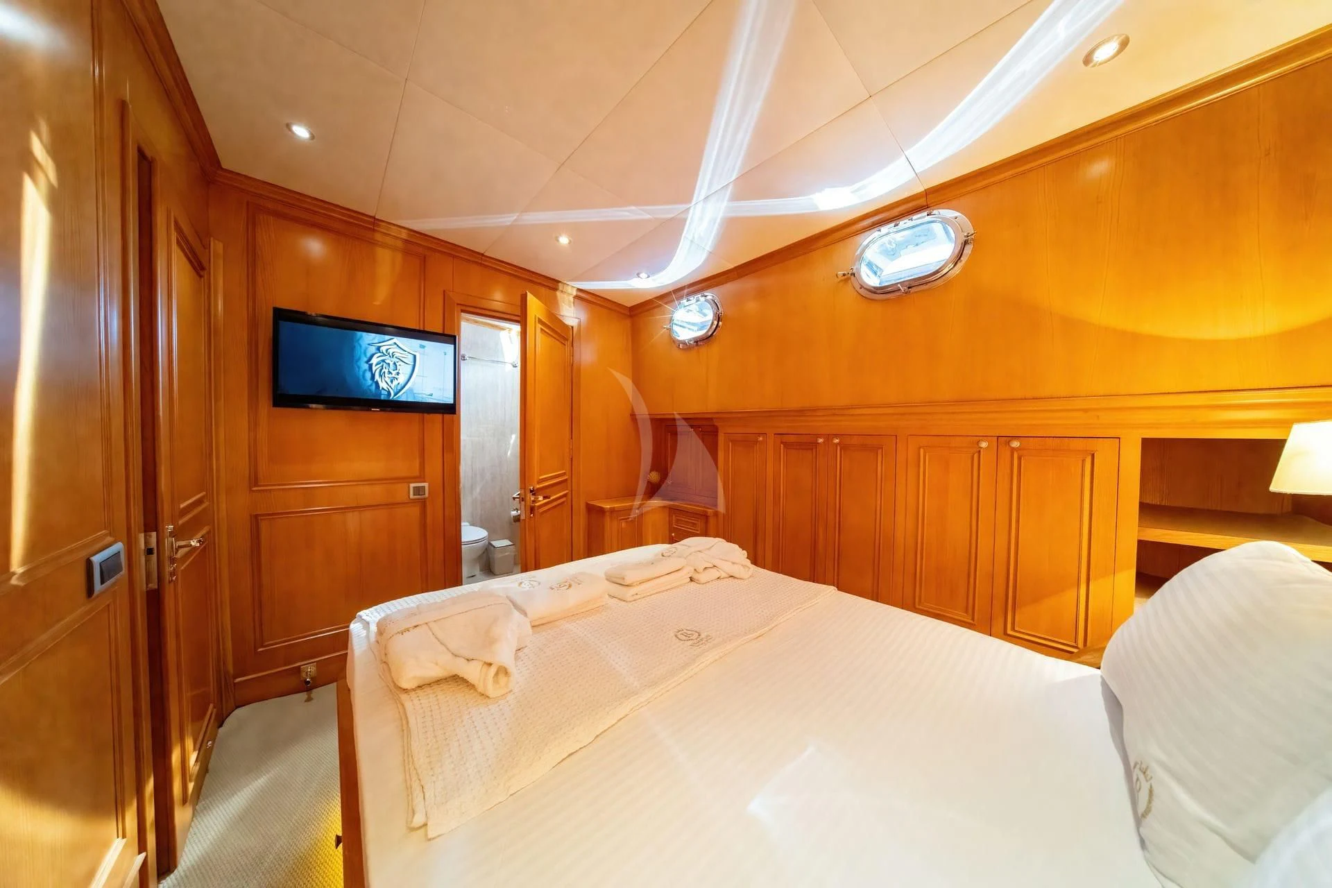 a room with wooden cabinets and a bed aboard BABYLON Yacht for Sale