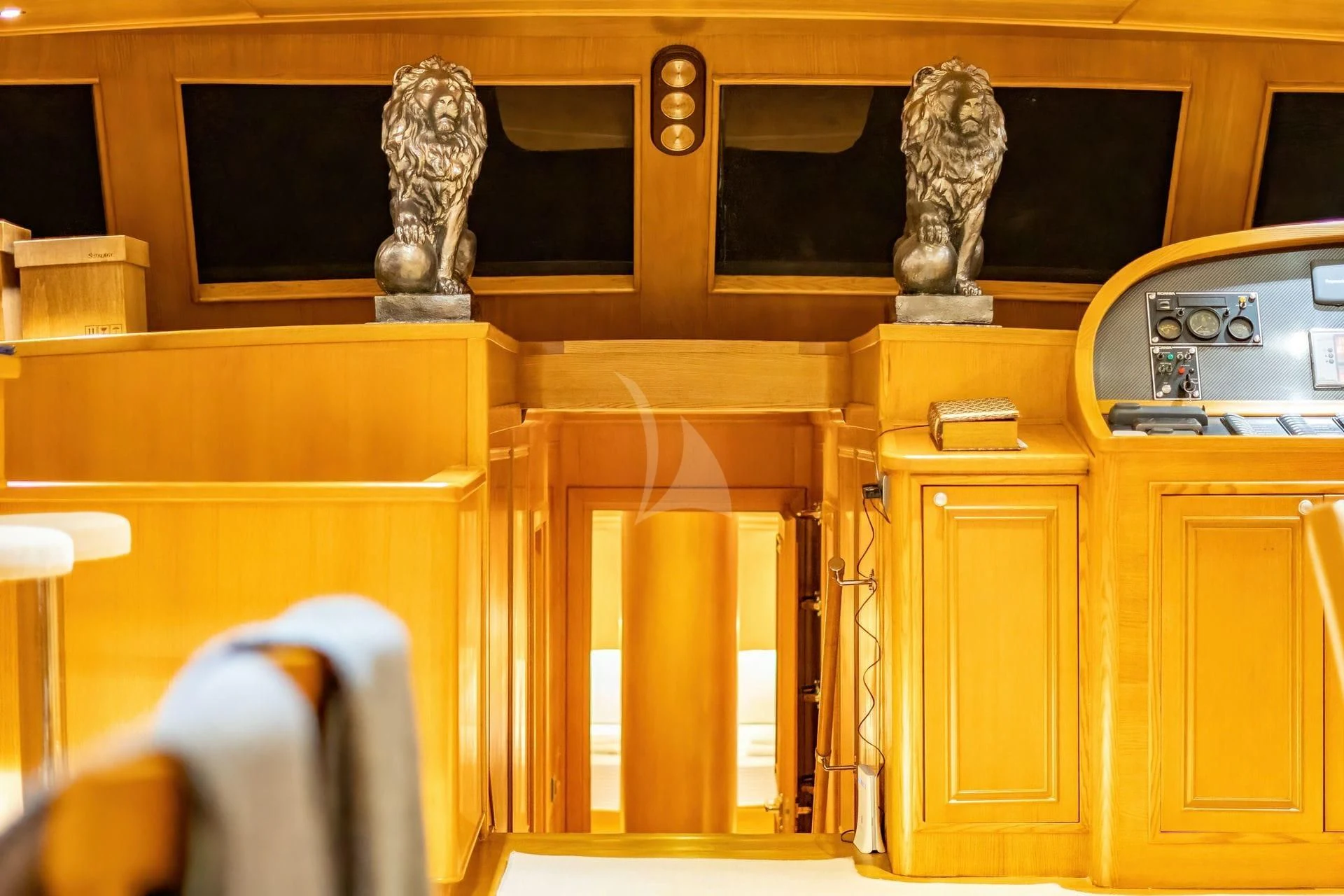 a room with a statue and a cabinet with chairs aboard BABYLON Yacht for Sale