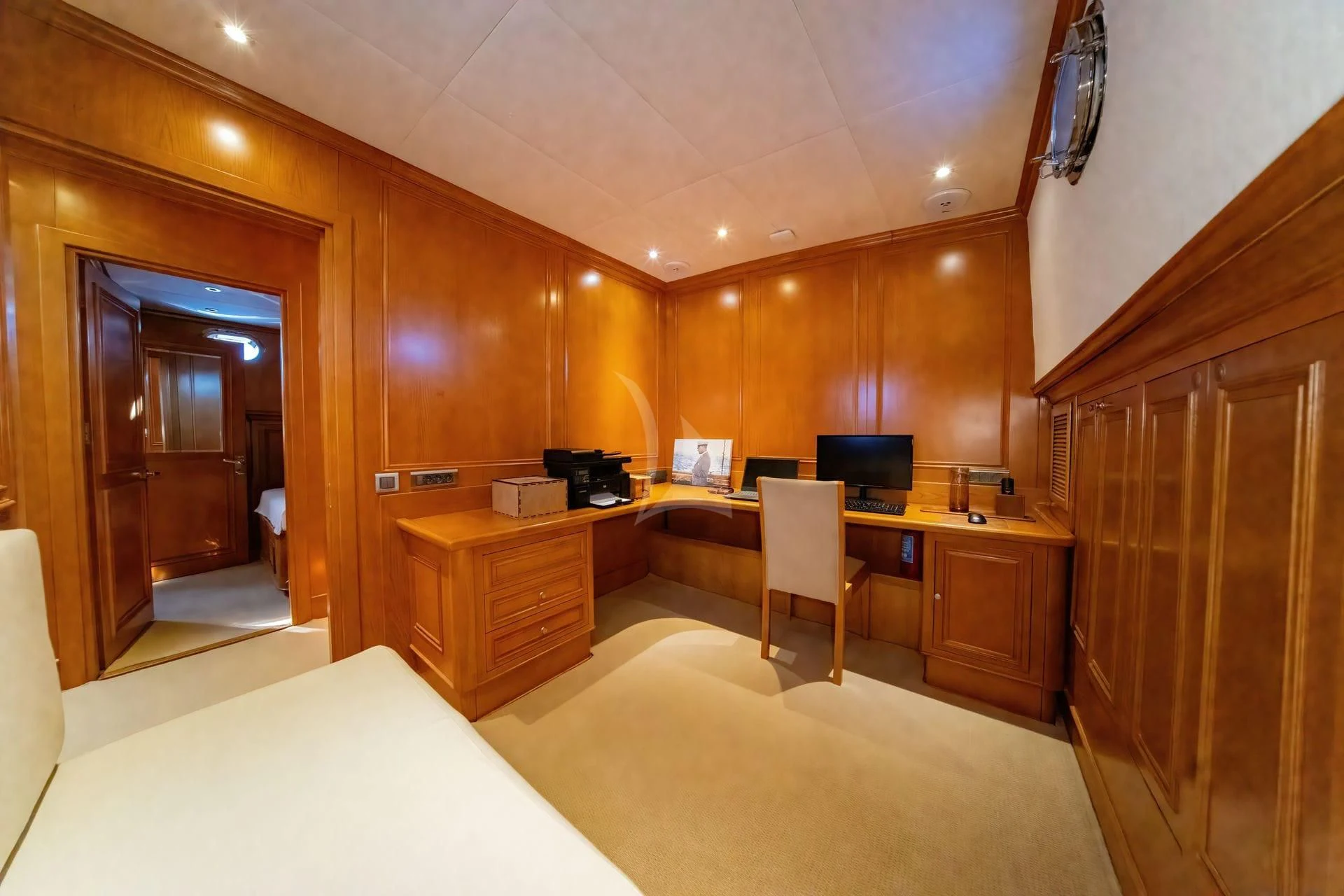 a room with a bed and desk aboard BABYLON Yacht for Sale