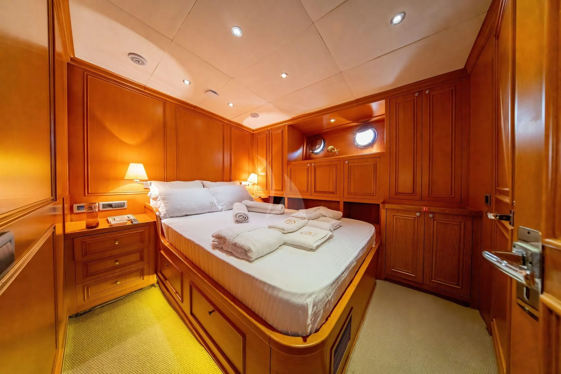 a large bedroom with wooden cabinets aboard BABYLON Yacht for Sale