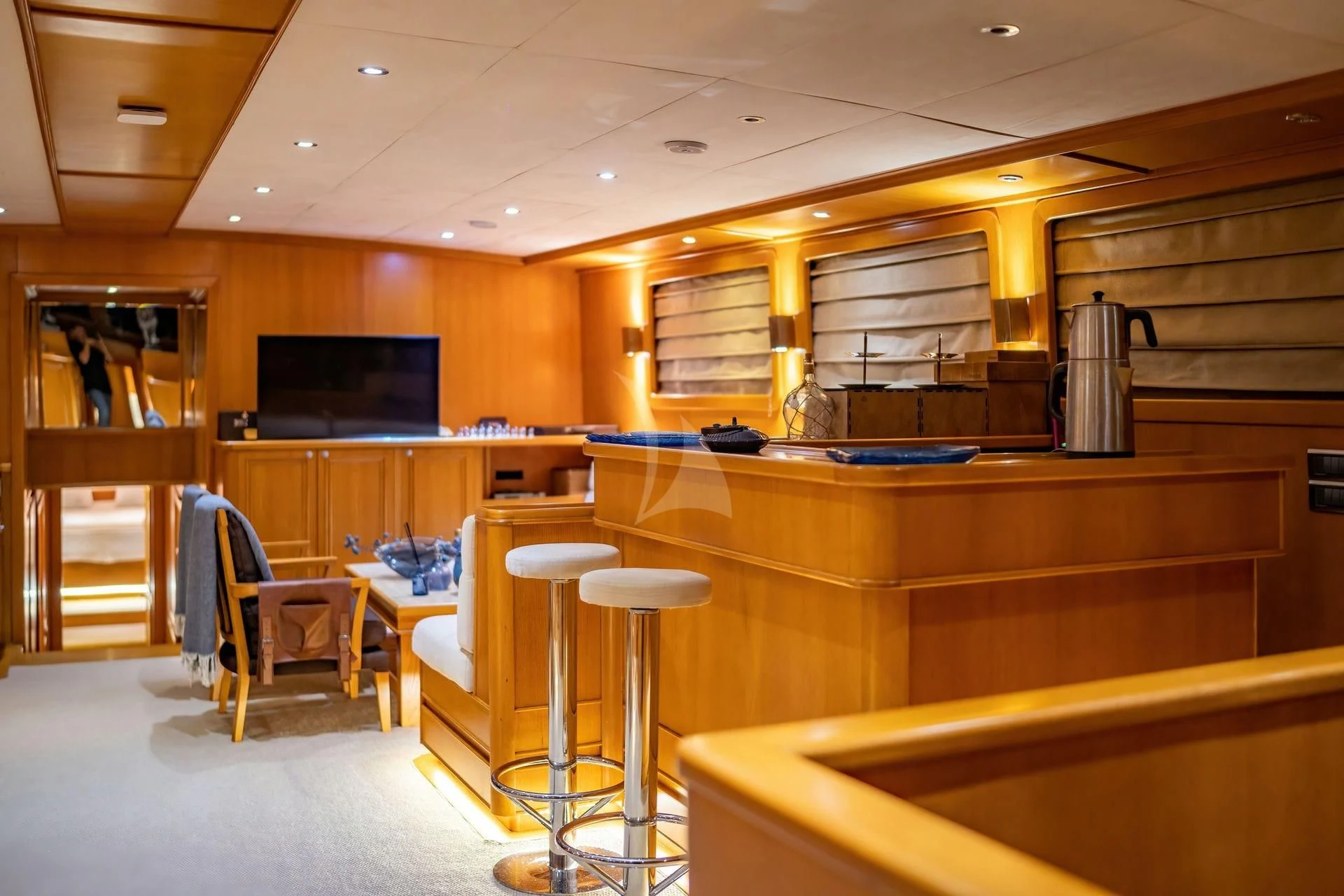 a room with a bar and stools and a tv aboard BABYLON Yacht for Sale