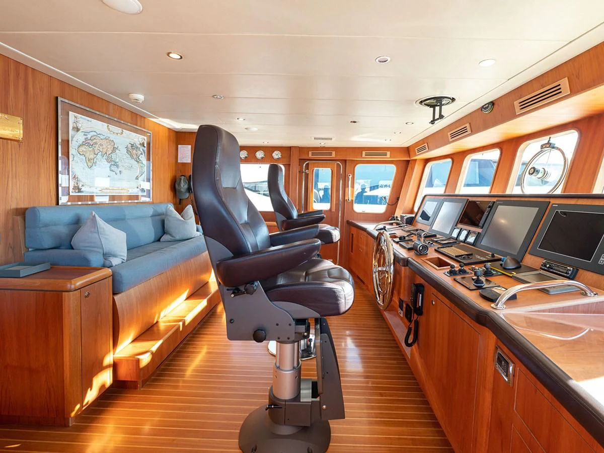 a room with a couch and a desk with computers aboard MOCEAN Yacht for Sale