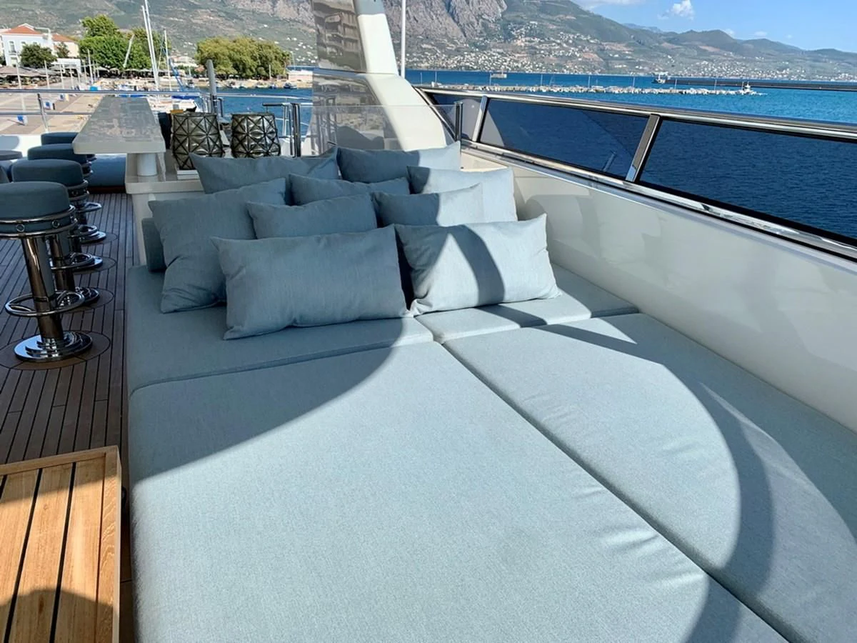 a large white lounge chair on a balcony overlooking a body of water aboard MOCEAN Yacht for Sale