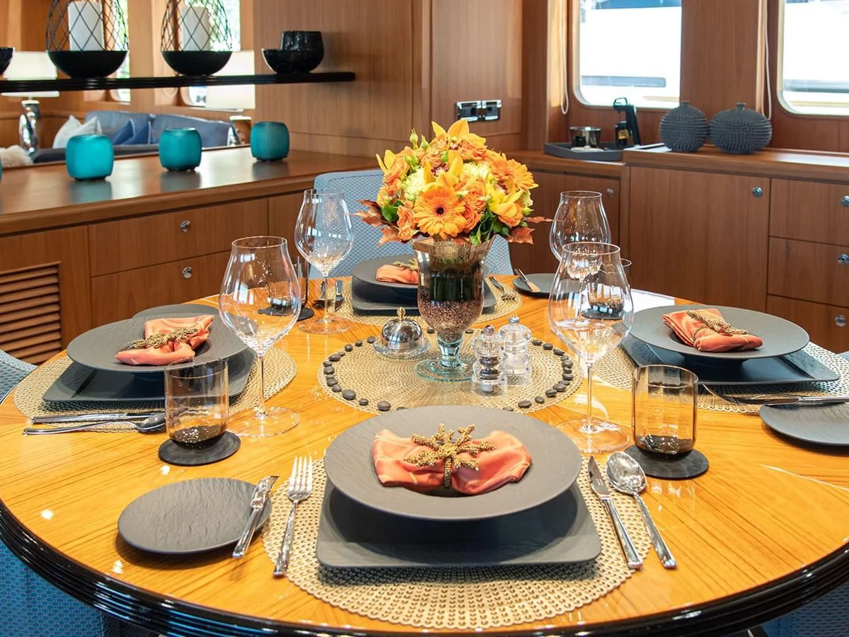 a table with plates and glasses aboard MOCEAN Yacht for Sale