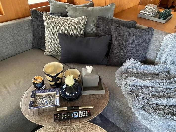 a coffee table with a glass of wine and a tray of food on it aboard MOCEAN Yacht for Sale