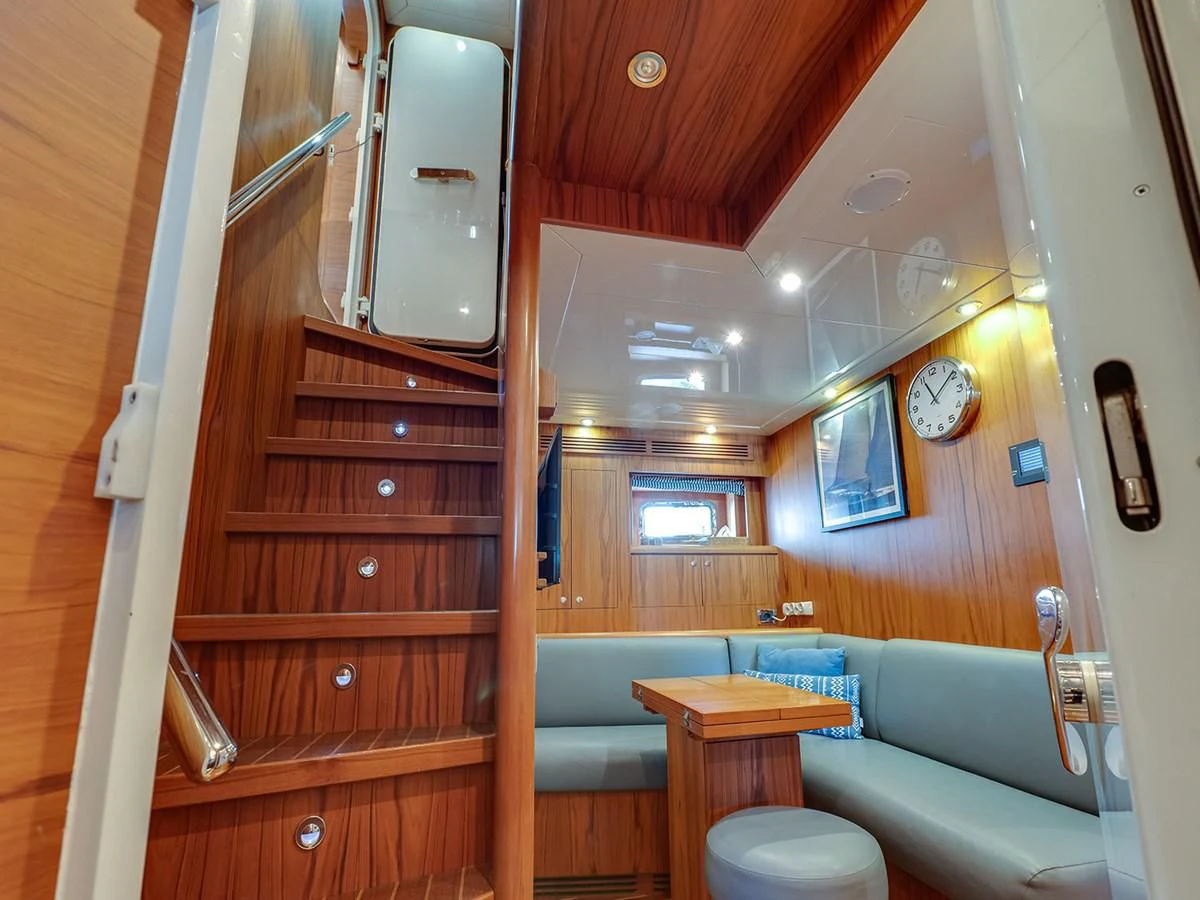 a wood cabin with a table and a bench aboard MOCEAN Yacht for Sale